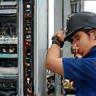 Broadband technician installing equipment at business site